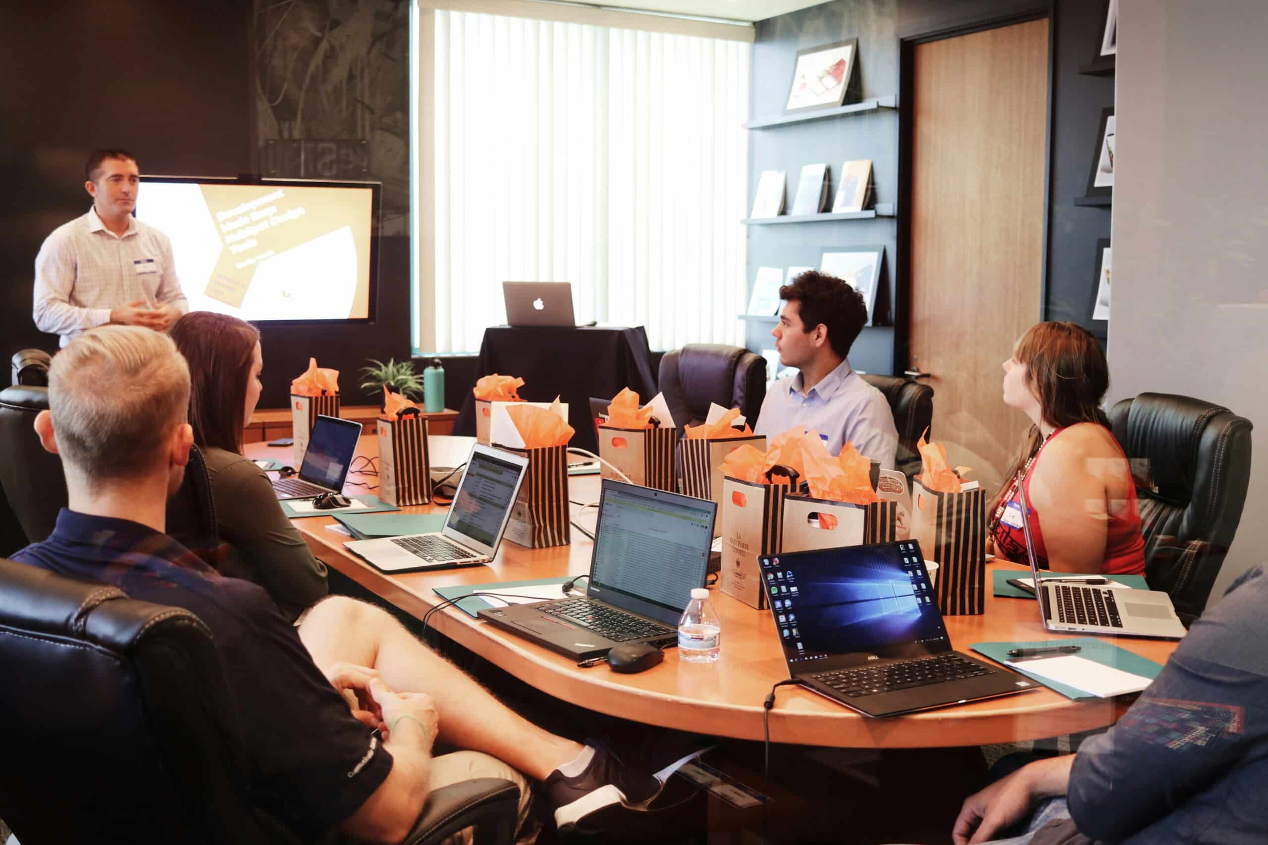 Office meeting with team working on laptops and collaboration