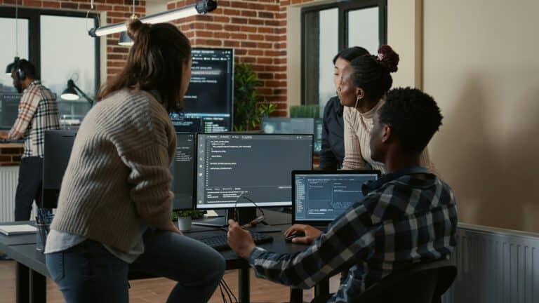 Team of developers coding and building responsive websites in modern workspace