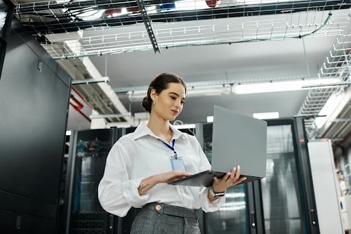 Female IT professional working on laptop managing cloud-based business systems